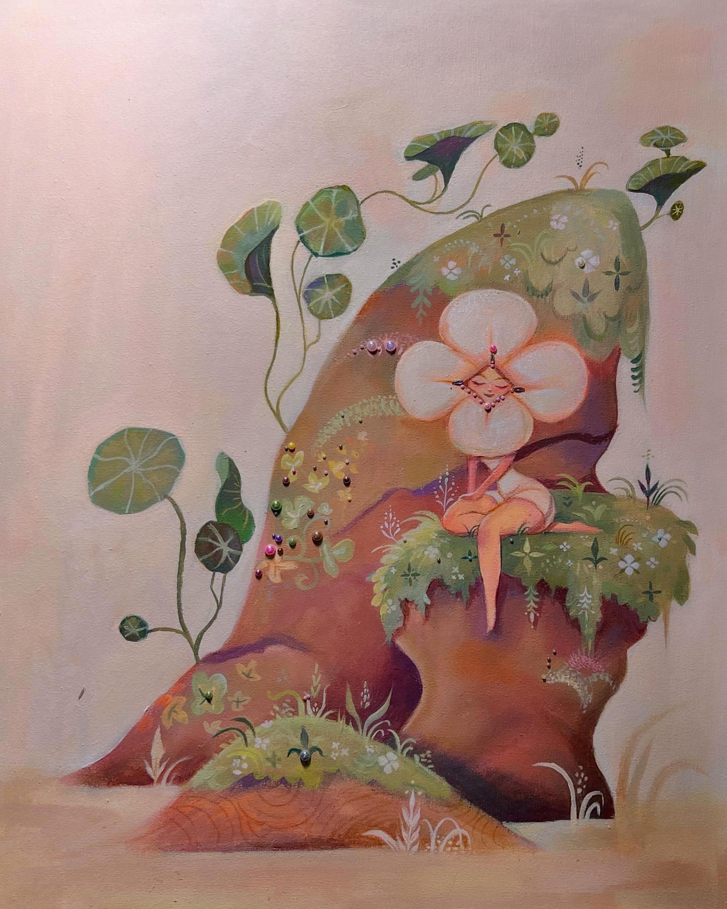 Flower fairy seated on mossy stone